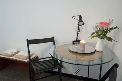 a glass table with a candle and a vase of flowers at Light of Rome in Rome