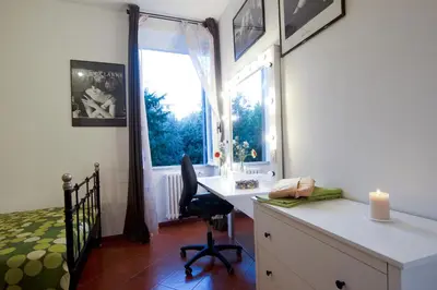 a bedroom with a desk and a window with a candle at Light of Rome in Rome