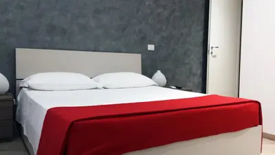 a bedroom with a large bed with a red blanket on it at Domus Barberini in Rome
