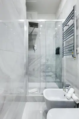 a white bathroom with a shower and a sink at V Collection Piazza Farnese Luxury Suites in Rome