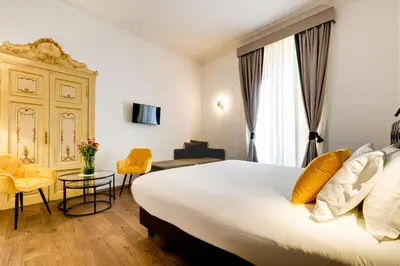 a hotel room with a large bed and a table at V Collection Piazza Farnese Luxury Suites in Rome