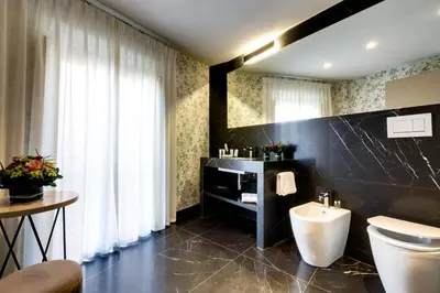 a bathroom with a toilet and a sink and a mirror at V Collection Piazza Farnese Luxury Suites in Rome