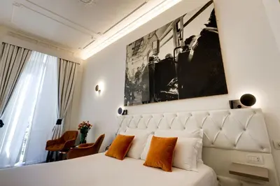 a bedroom with a white bed with orange pillows at V Collection Piazza Farnese Luxury Suites in Rome