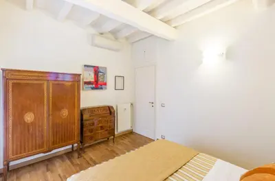 a room with a wooden cabinet and a painting on the wall at Al Centro Storico Roma Suite in Rome
