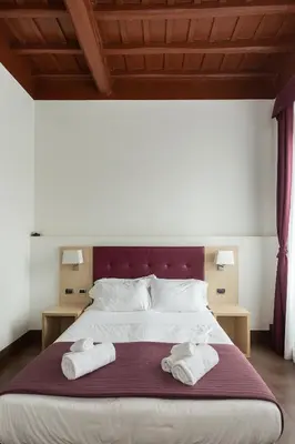 a bedroom with a large bed with two towels on it at SuitInn19 in Rome