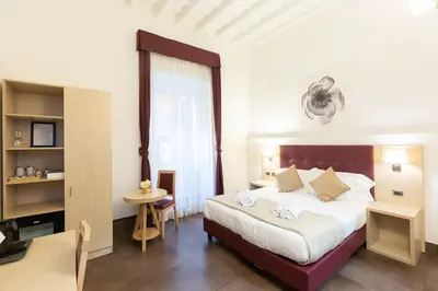 a bedroom with a bed and a table and a desk at SuitInn19 in Rome