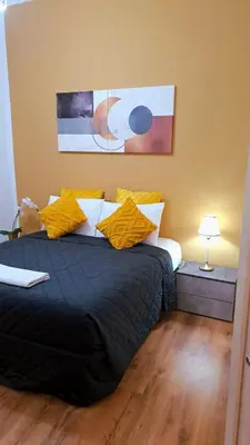 a bedroom with a large black bed with yellow pillows at Appia Avenue 639 in Rome