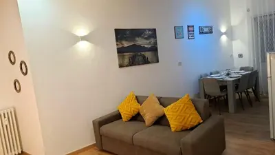 a living room with a brown couch with yellow pillows at Appia Avenue 639 in Rome