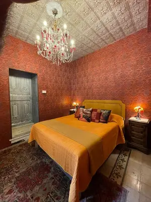 a bedroom with a bed and a chandelier at B&B Ventisei Scalini A Trastevere in Rome