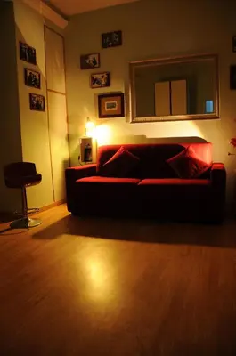 a living room with a red couch and a lamp at Simon Holiday House in Rome