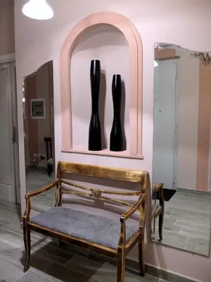 a bench in a room with a mirror and black boots at Dimora Al 36 in Rome