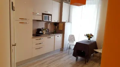 a kitchen with white cabinets and a table and a window at Luiza Vatican House in Rome