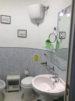 a bathroom with a sink and a toilet and a mirror at Luiza Vatican House in Rome
