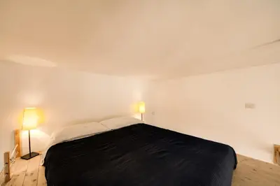 a bedroom with a large bed with two lamps at Ponte Testaccio Loft in Rome