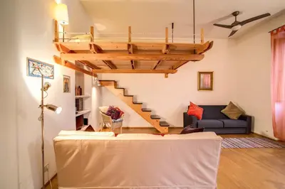 a living room with a couch and a wooden staircase at Ponte Testaccio Loft in Rome