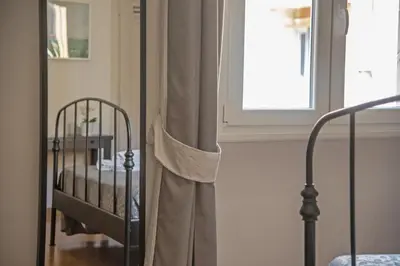 a bed in a room with a window and a curtain at San Pietro Holidays in Rome