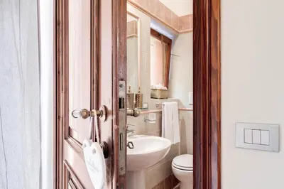 a bathroom with a toilet and a sink at Elegant Apartment Behind the Colosseum in Rome