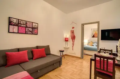 a living room with a couch and a bedroom at Elegant Apartment Behind the Colosseum in Rome