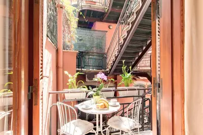 a table and chairs on a balcony with stairs at Elegant Apartment Behind the Colosseum in Rome