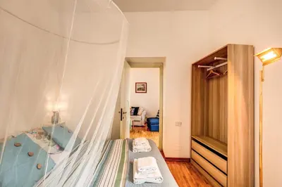 a bedroom with a bed with a mosquito net at Elegant Apartment Behind the Colosseum in Rome