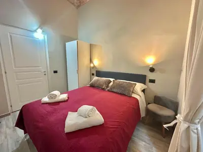 a bedroom with a red bed with two towels on it at Român Holidays in Rome