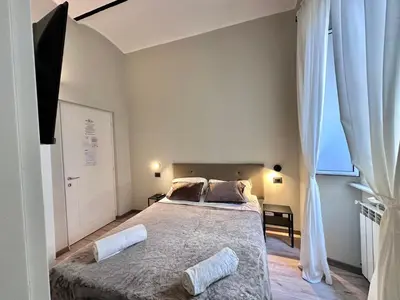 a bedroom with a large bed with two pillows on it at Român Holidays in Rome
