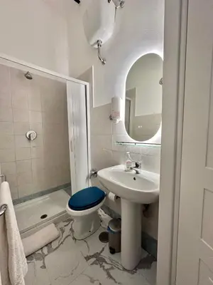 a bathroom with a sink and a toilet and a mirror at Român Holidays in Rome