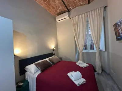 a bedroom with a red bed with towels on it at Român Holidays in Rome