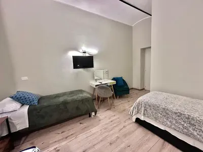 a bedroom with two beds and a desk with a television at Român Holidays in Rome