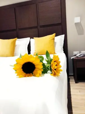 a bed with a bouquet of sunflowers on it at House Garden in Rome