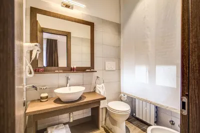 a bathroom with a sink and a toilet and a mirror at House Garden in Rome