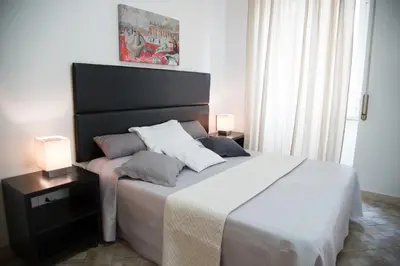 a bedroom with a large bed with two lamps on it at Casa Alberone in Rome
