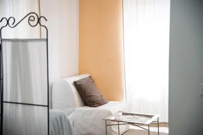a living room with a chair and a table at Casa Alberone in Rome