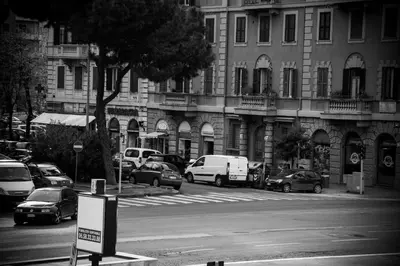 a busy city street with cars parked in front of buildings at Casa Alberone in Rome