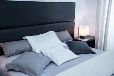 a bed with white pillows and a black headboard at Casa Alberone in Rome