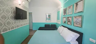 a blue room with a bed and a couch at The B Place Cola in Rome