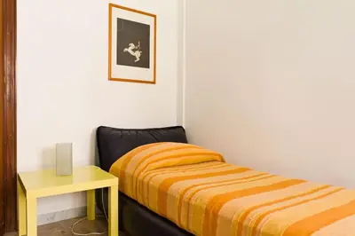 a small bedroom with a bed and a yellow table at A Casa di Pe' Casa Vacanze in Rome