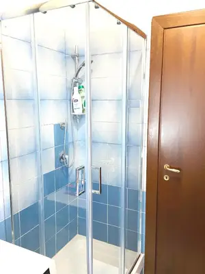 a shower in a bathroom with blue tiles at Piazza Meucci in Rome