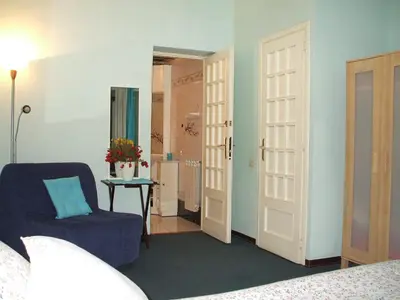 a bedroom with a blue chair and a door at B&B A Casa Di Nancy in Rome