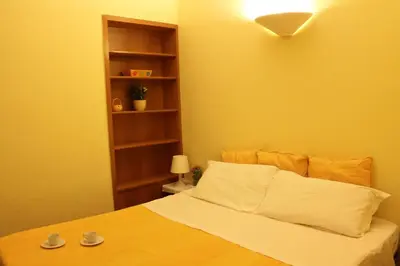 a bedroom with a bed with a yellow wall at B&B A Casa Di Nancy in Rome
