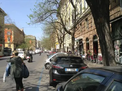 a woman walking down a city street with a car at B&B A Casa Di Nancy in Rome