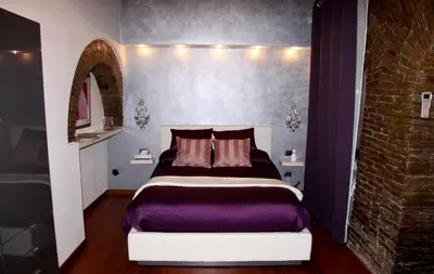 a bedroom with a bed and a brick wall at Domus31 - Luxury House in Trastevere in Rome