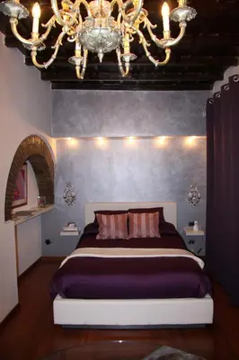 a bedroom with a large bed and a chandelier at Domus31 - Luxury House in Trastevere in Rome