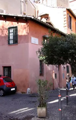 a pink building with a car parked in front of it at Domus31 - Luxury House in Trastevere in Rome