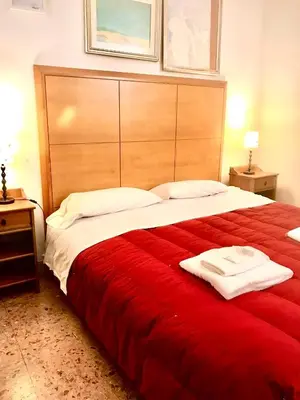 a bedroom with a large bed with a red blanket at Le Sibille in Rome