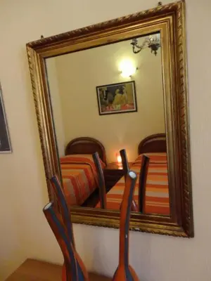 a mirror on a wall with a bed in a room at Oltre le Mura in Rome