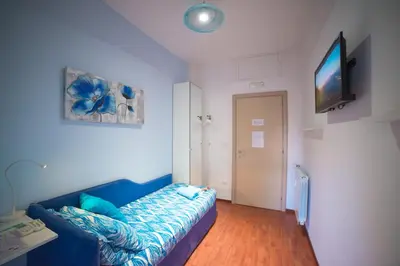 a living room with a blue couch and a flat screen tv at Green Line in Rome