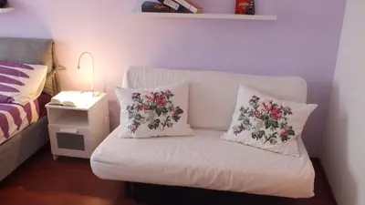 a white couch with two pillows on it in a bedroom at Green Line in Rome