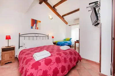 a bedroom with a red bed and a tv at Sixtythree guesthouse in Rome