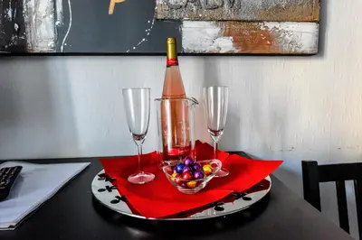 a table with two wine glasses and a bowl of fruit at ACasaDiEnza in Rome